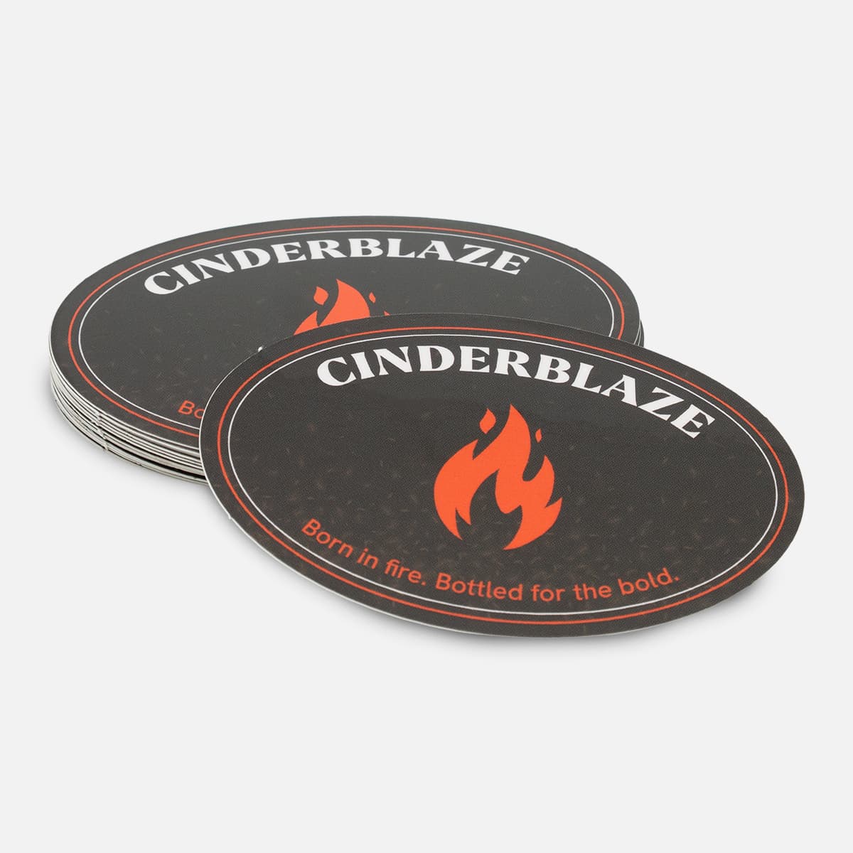 Stack of custom oval Cinderblaze stickers with a black and red fire logo design and bold white lettering.