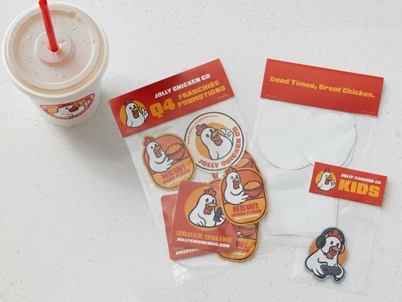 Fast food themed sticker pack with chicken mascot stickers, header cards, and a branded drink cup displayed on a white surface.