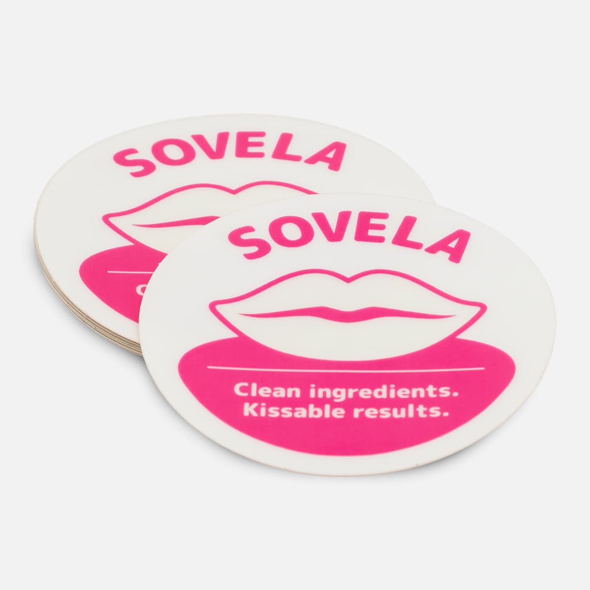 Stack of custom oval Sovela stickers with a bright pink lip care design and clean ingredients message.