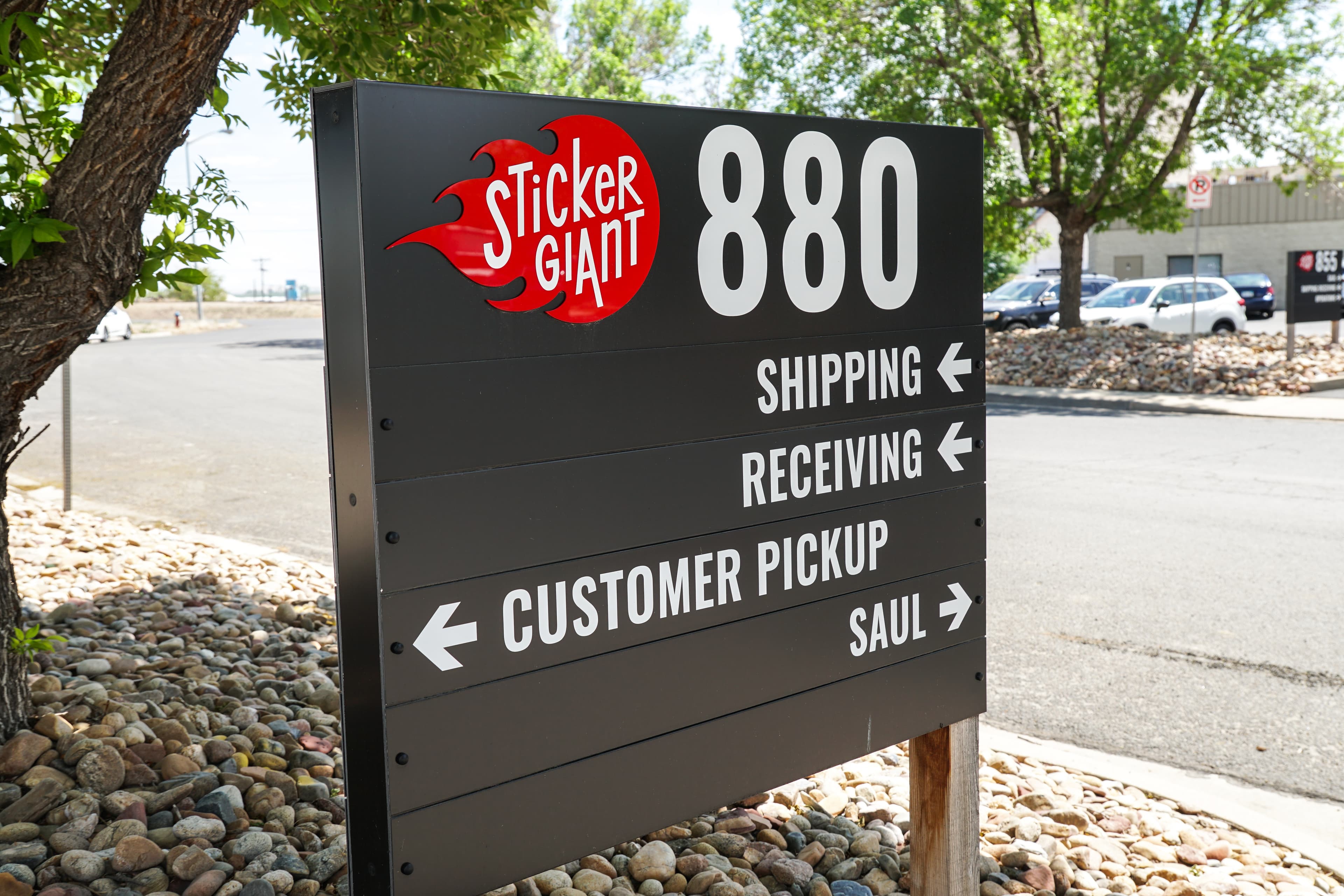 StickerGiant facility sign in Longmont, Colorado showing directions for shipping, receiving, and customer pickup.