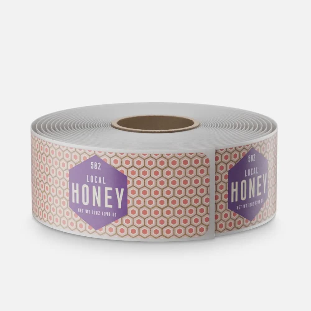 Custom kraft paper labels on a roll featuring honey product packaging artwork printed on natural brown paper material.