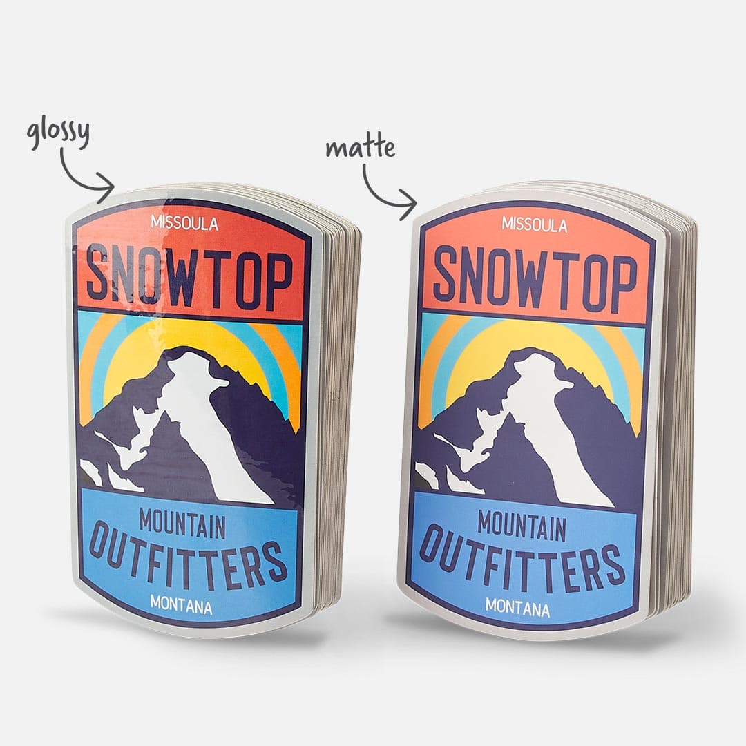 Side-by-side comparison of custom White BOPP die cut stickers in glossy and matte lamination, featuring a Snowtop Mountain Outfitters design