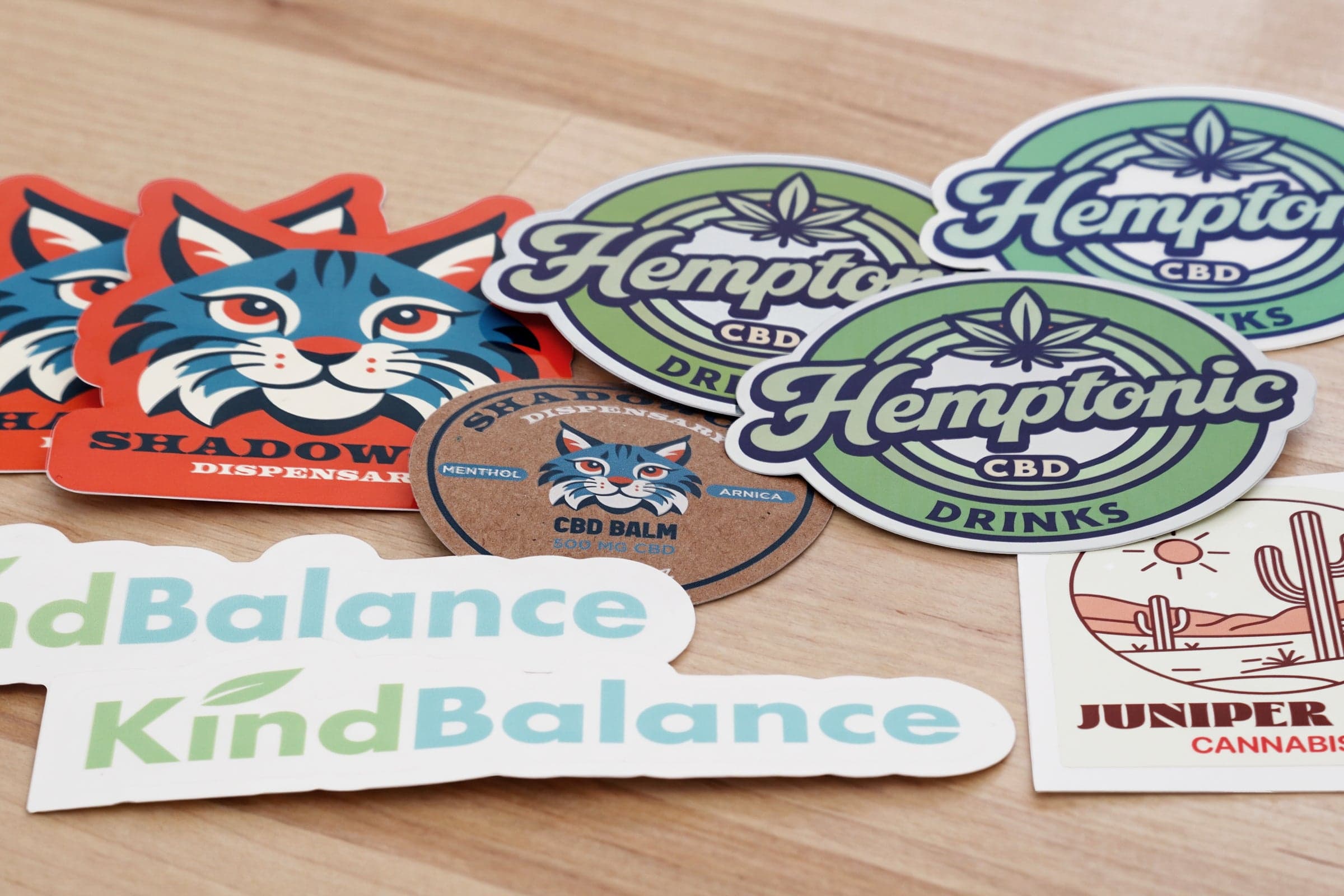 Assortment of custom cannabis stickers and product labels featuring multiple brand designs.