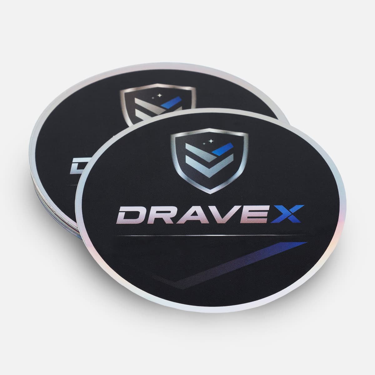 Stack of round black DriveX stickers with a shield logo, blue checkmark, and holographic edge detail.