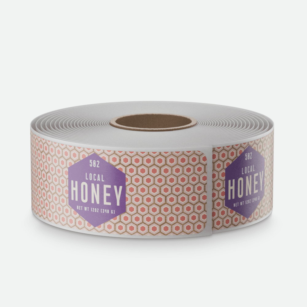 A roll of patterned “Local Honey” product labels with purple hexagon logos is displayed on a light gray background.