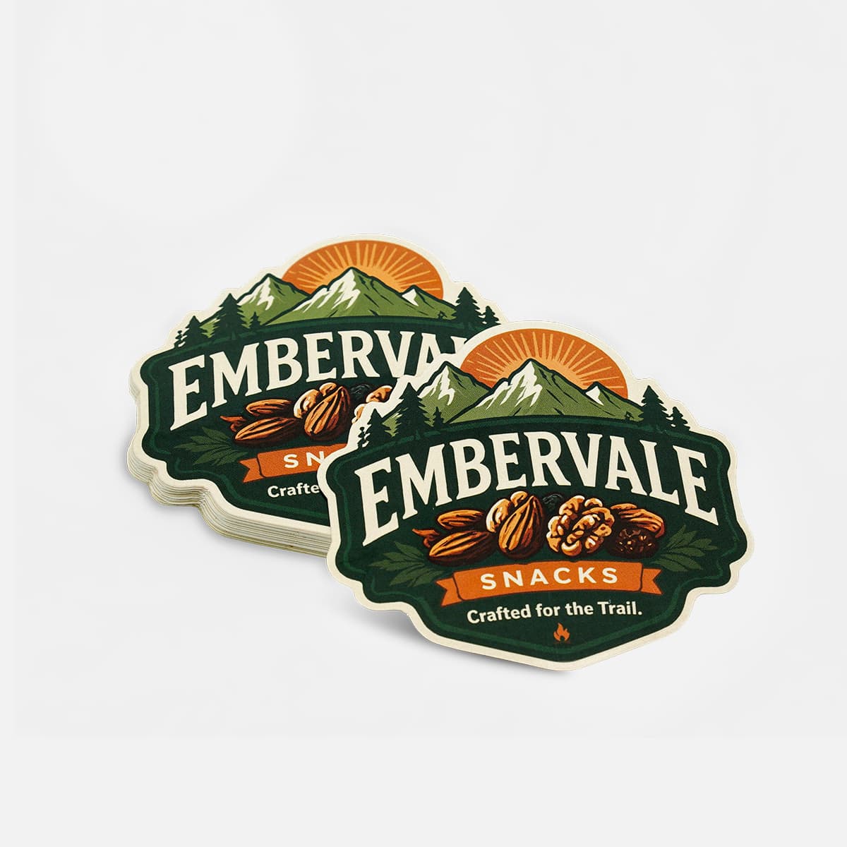 Stack of custom die cut snack packaging stickers featuring mountain-themed food branding.