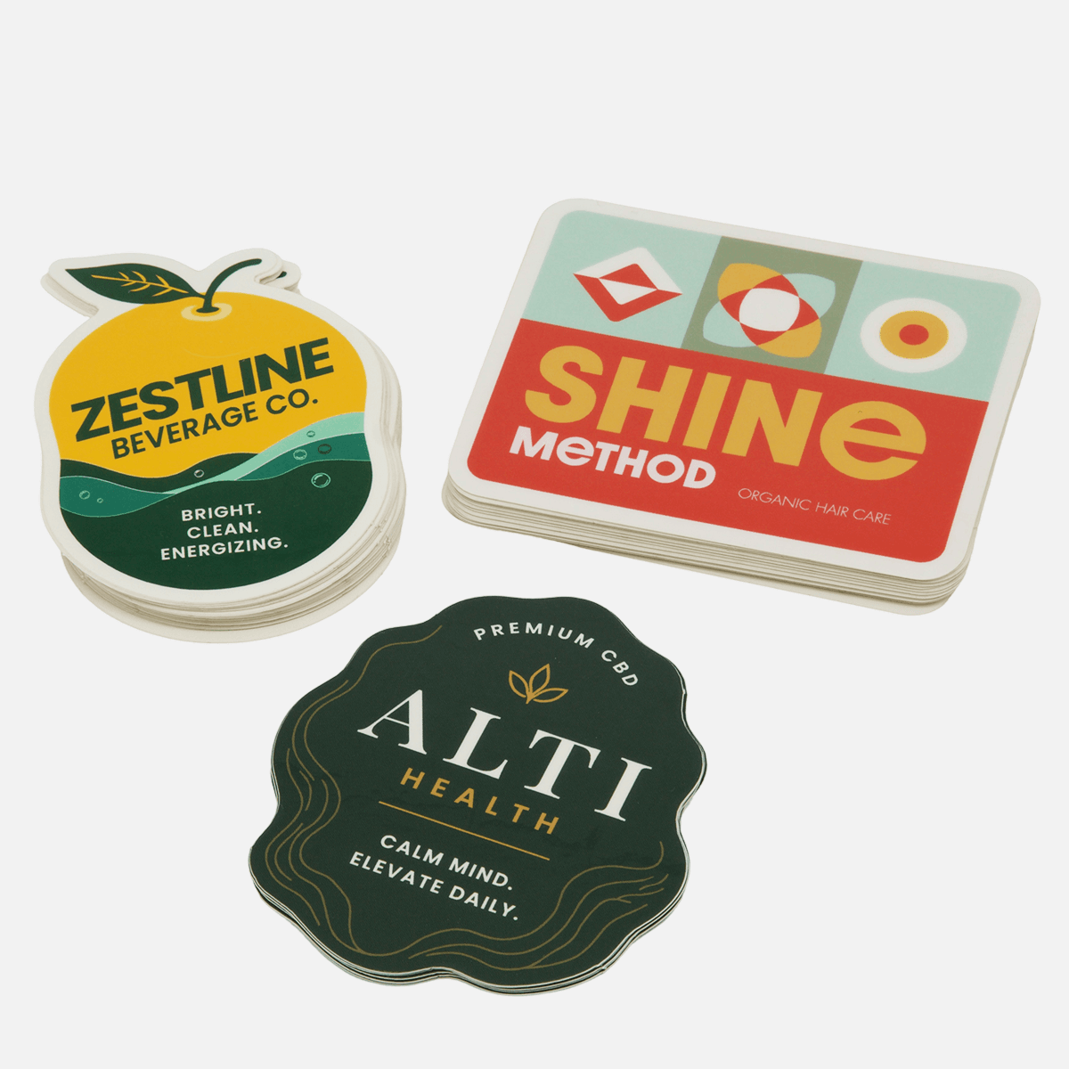 Custom die cut stickers in unique shapes and sizes featuring beverage, beauty, and wellness branding with vibrant full color printing.