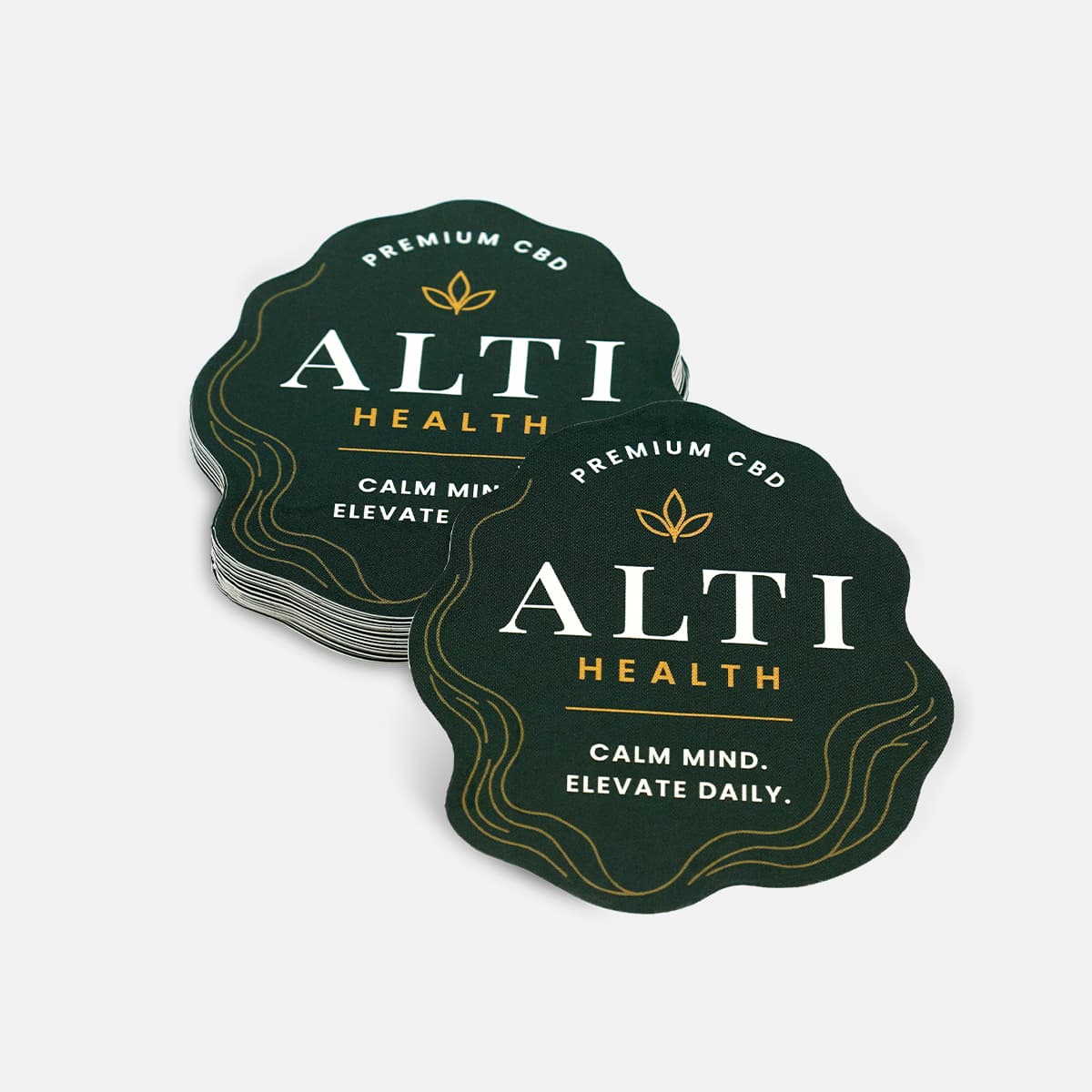 Stack of custom die cut CBD product stickers with premium wellness branding and white border.