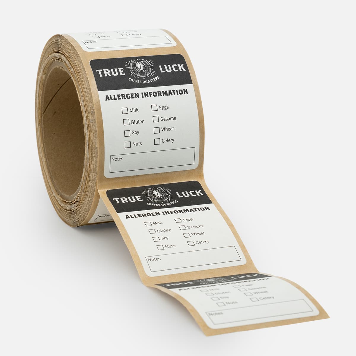 Roll of True Luck Coffee Roasters allergen information labels with checkboxes for common ingredients and a notes section.