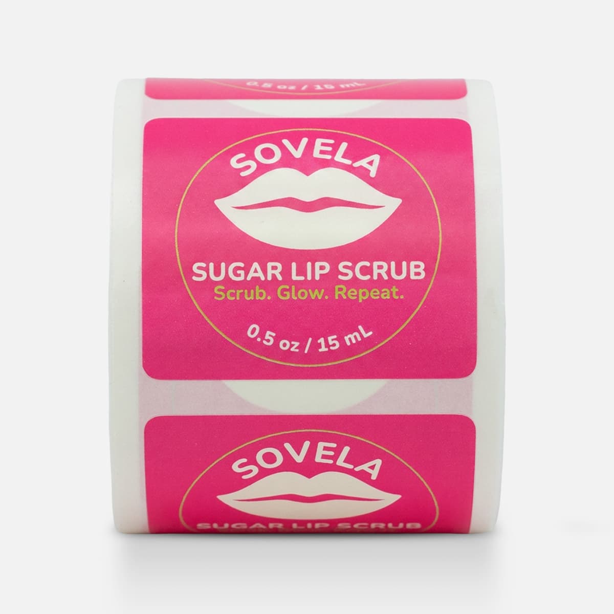 Roll of custom sugar lip scrub labels for Sovela with a bright pink design, lip icon, and gold circle accent.