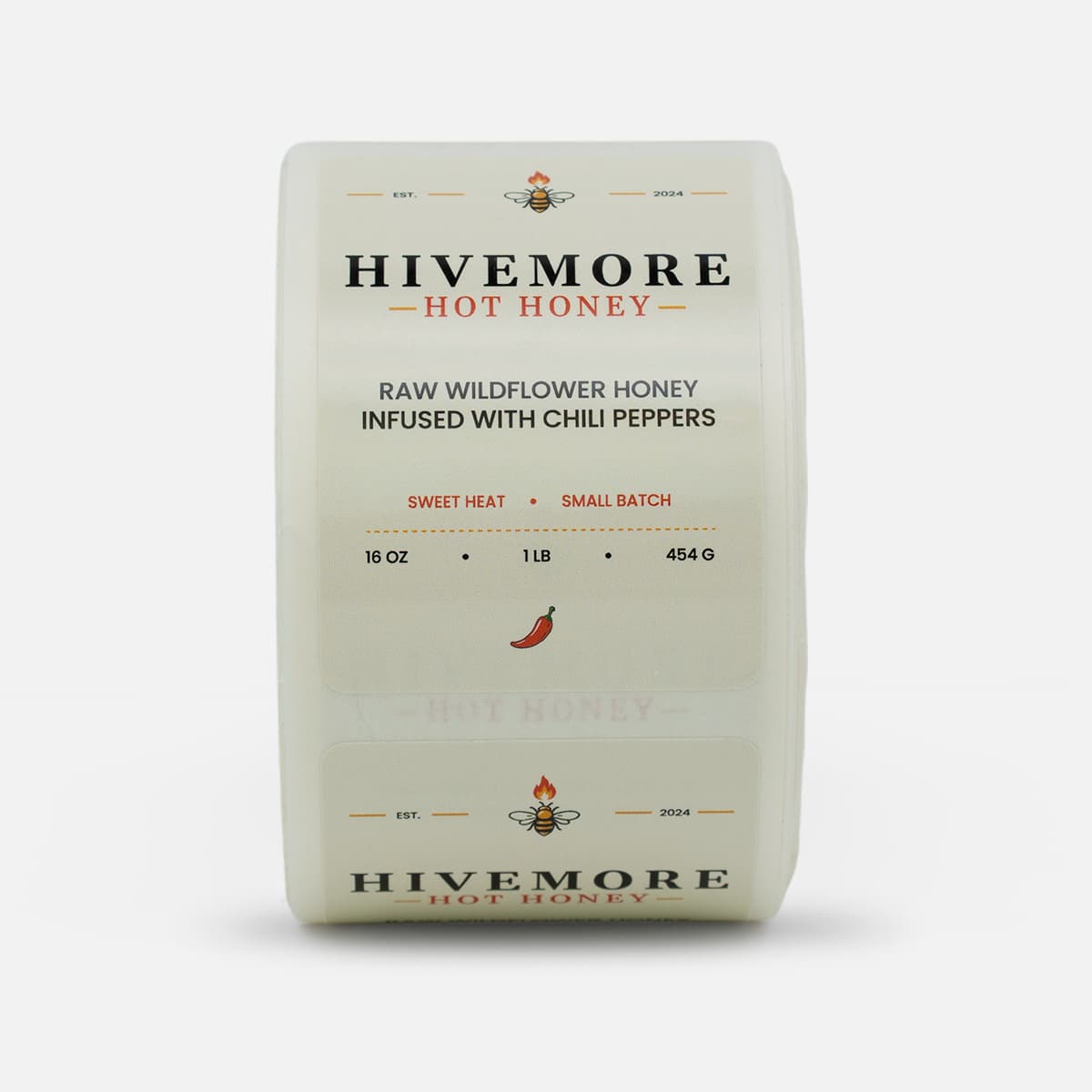 Roll of custom Hivemore Hot Honey labels featuring cream packaging artwork with bee and chili pepper details.